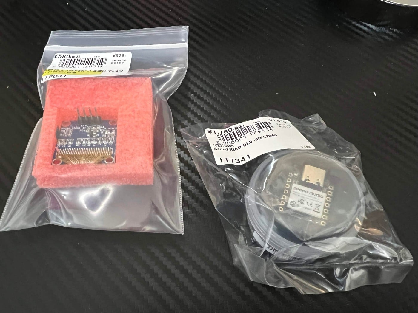 袋に入ったOLEDモジュールとSeeed XIAO nRF52840